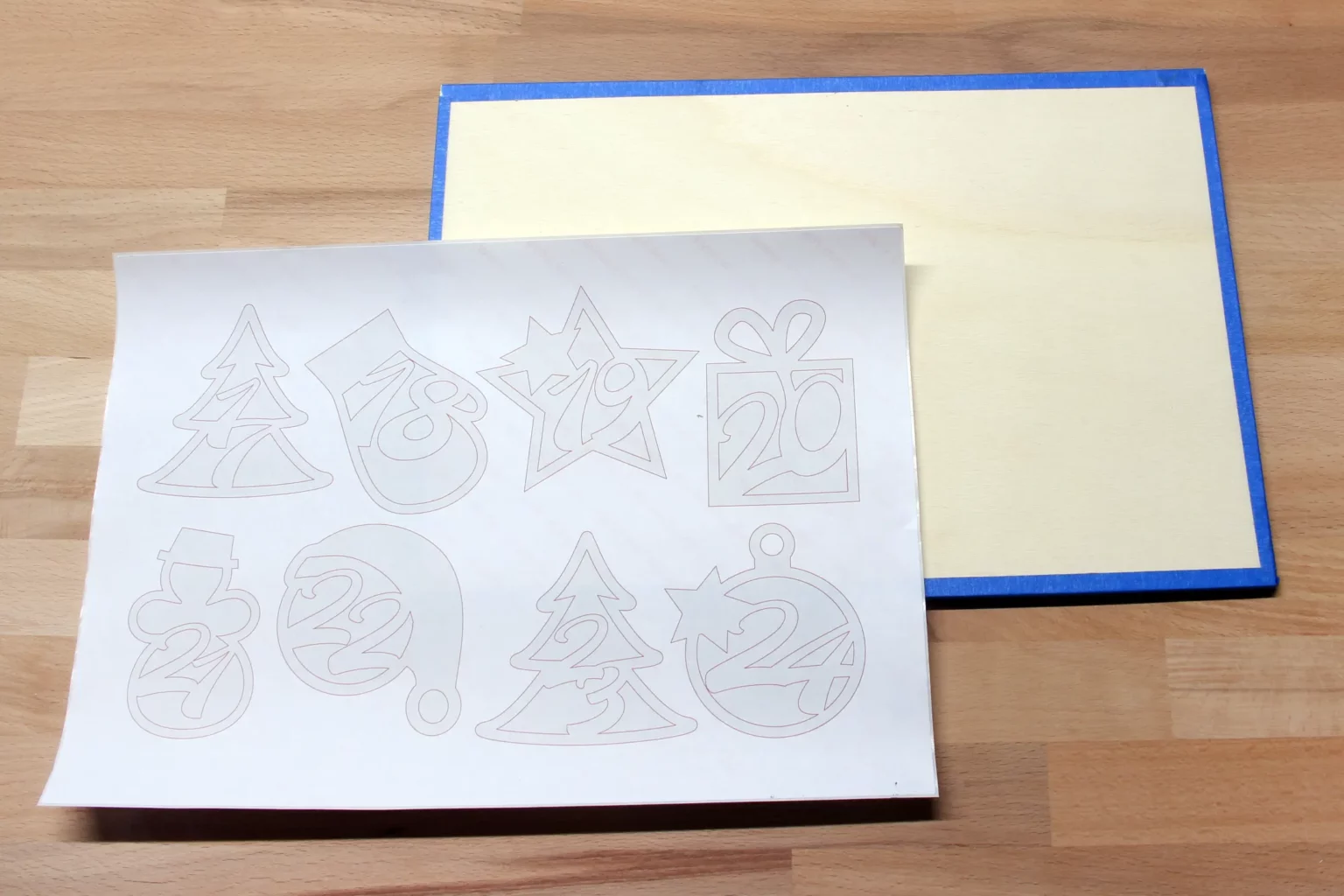 29-02-adventskalender-zahlen-laubsaege-dekupiersaege-vorlage-sperrholz-blue-tape-stapel-fixieren-vorlagenpapier-aufkleben