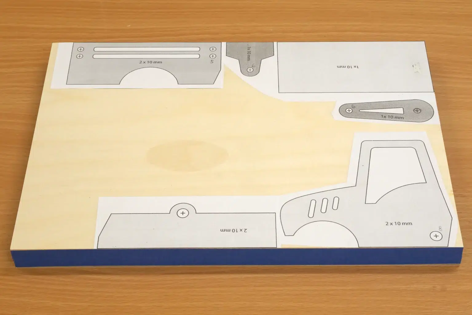 15-03-traktor-mit-anhaenger-spielzeug-laubsaege-dekupiersaege-vorlage-sperrholz-blue-tape-stapel-fixieren-vorlagenpapier-aufkleben
